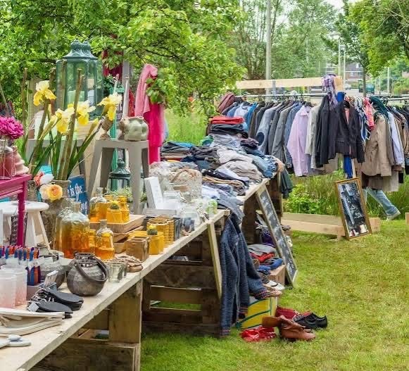 Troc au Bocal de Landas : tables de vêtements, jouets, livres, bocaux et fleurs sur le terrain